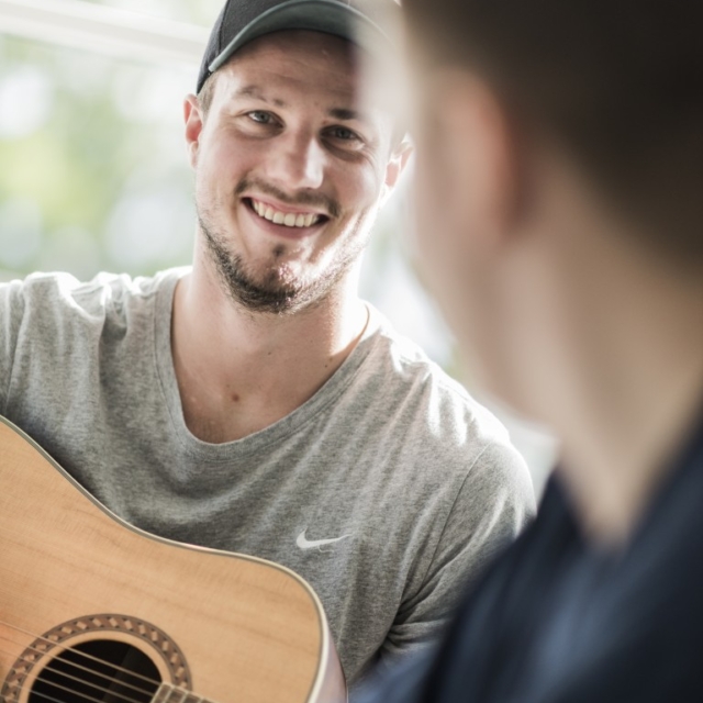 Kontaktperson og ung med guitar